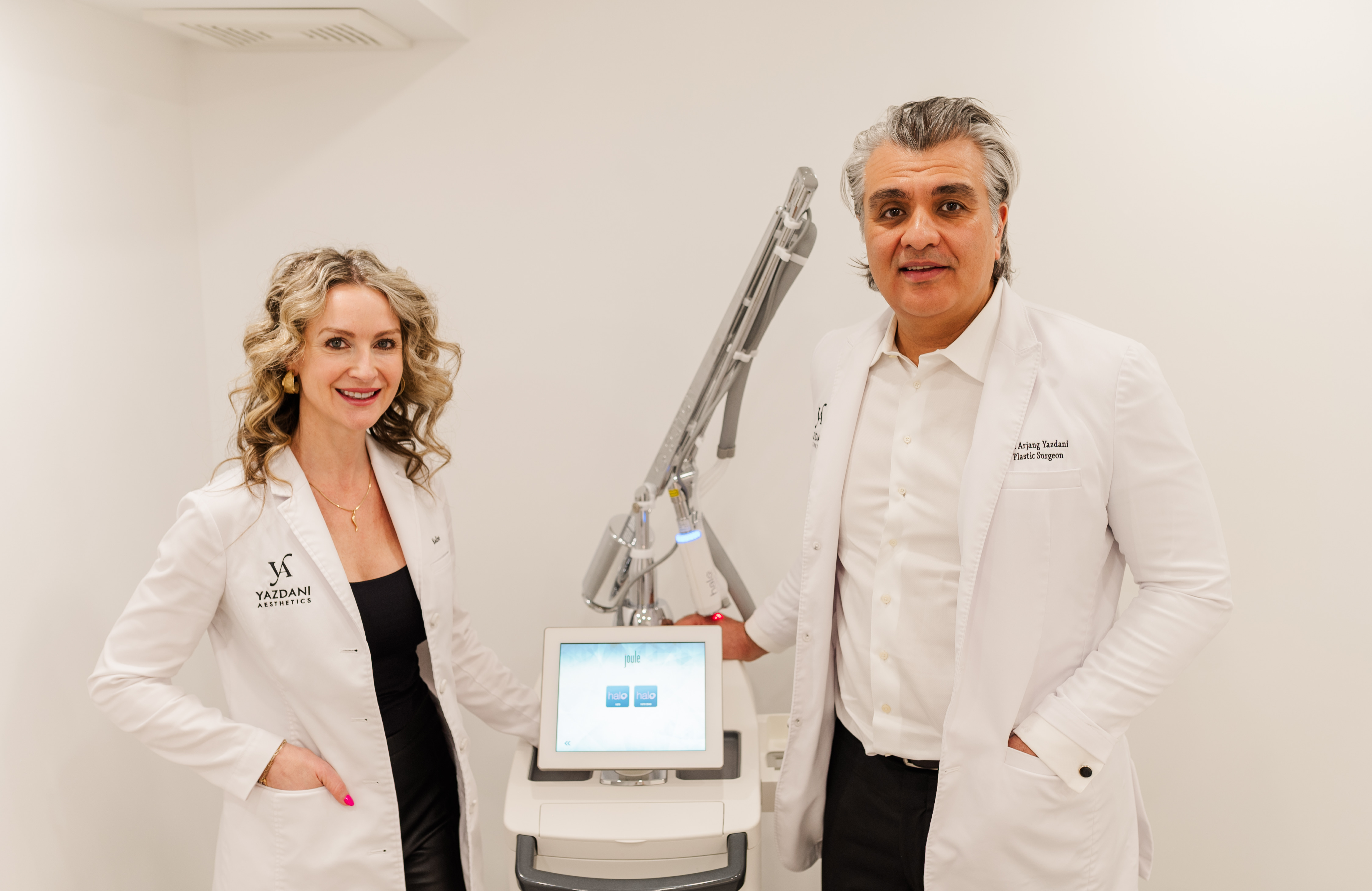 Nadine Sabino and Dr. Arjang Yazdani beside a Sciton Joule laser system at Yazdani Aesthetics
